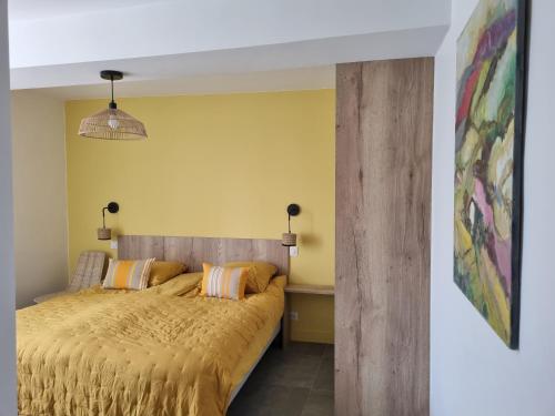 a bedroom with a bed and a yellow wall at Maison Arios in Came