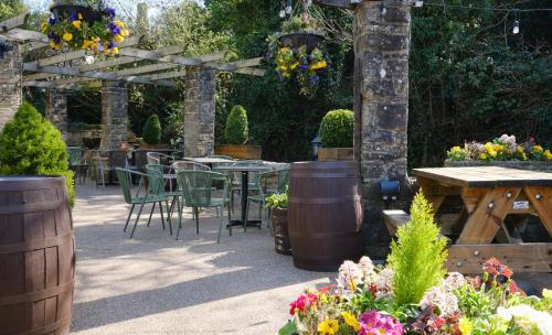 an outdoor patio with tables and chairs and flowers at Scotsman's Pack Hotel in Hathersage