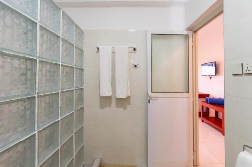 a bathroom with a shower and a glass door at Malika Blue Hotel Nungwi, Zanzibar in Banda Kuu