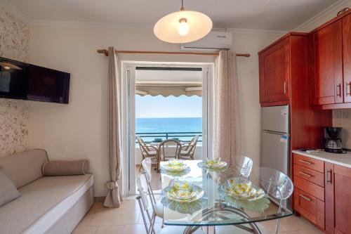 a kitchen with a glass table with a view of the ocean at Corfu Glyfada Beach Apartment 86 in Glyfada