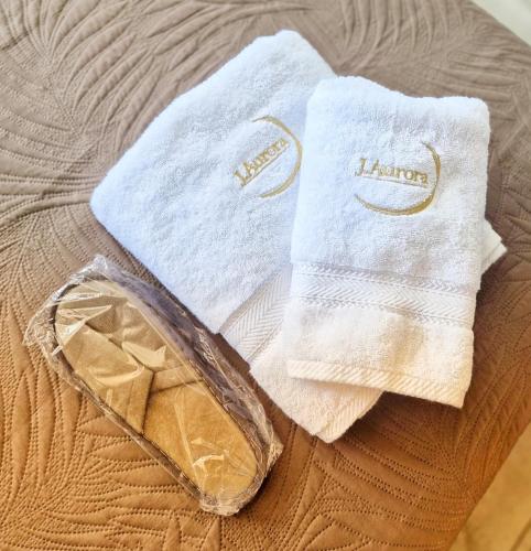 a pair of towels and a bag on a bed at J Aurora in Nicosia