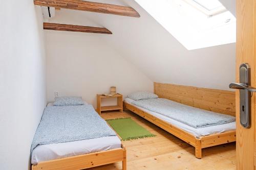 two beds in a room with a window at Apartmán Maštal in Osek