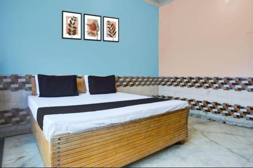 a bed in a room with two pictures on the wall at Samrat Hotel in Sambhal