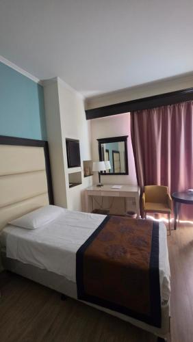 a hotel room with a bed and a desk at Castelli Hotel Nicosia in Nicosia
