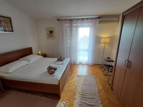 a small bedroom with a bed and a window at Tucepi Kamena 57 in Tučepi