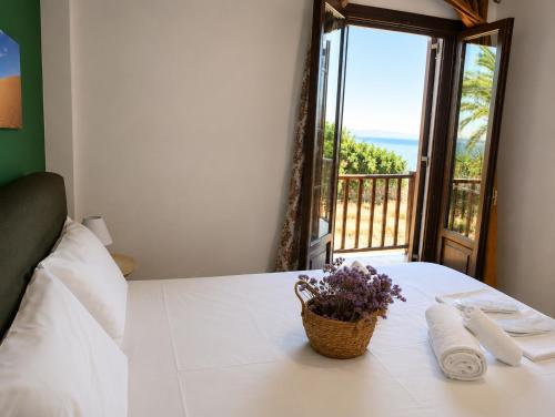a bedroom with a bed with a view of the ocean at TERRA LEMNIA in Moúdhros