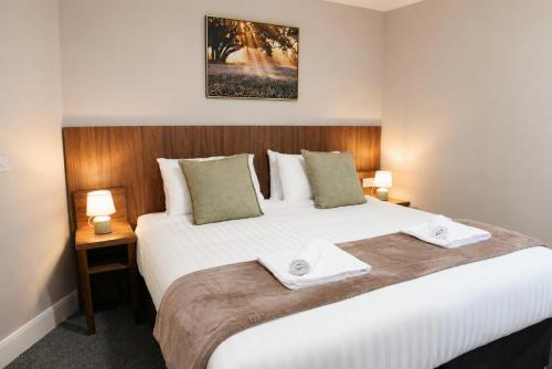 a bedroom with a large white bed with two lamps at Coach House Accommodation - Room 3 in Carrick on Shannon