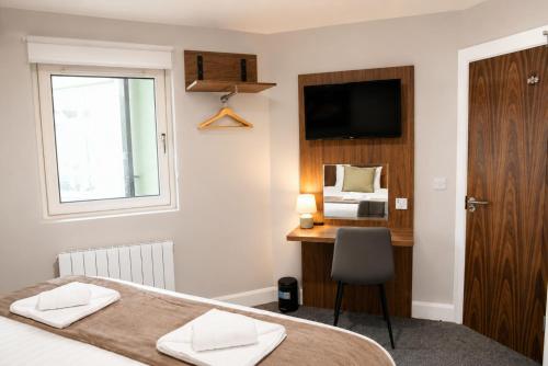 a bedroom with a bed and a desk and a television at Coach House Accommodation - Room 3 in Carrick on Shannon