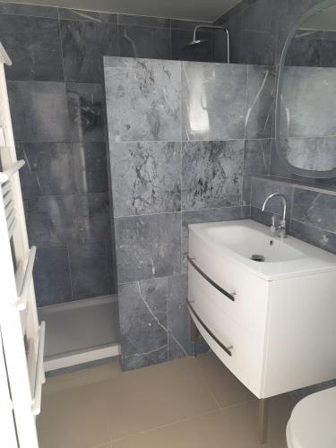 a bathroom with a white sink and a shower at Césaria in Loupian