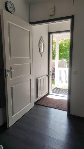 a room with an open door and a clock on the wall at Hartikkalan Apartments in Lappeenranta