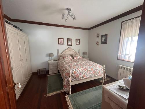 a bedroom with a bed and a chandelier at Casa abuelo Ramón in Narón