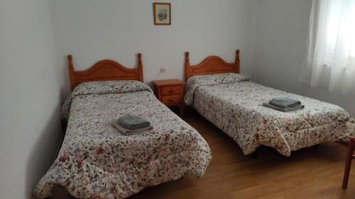 two beds in a small room with two at Hostal Restaurante Moderno in Cistierna