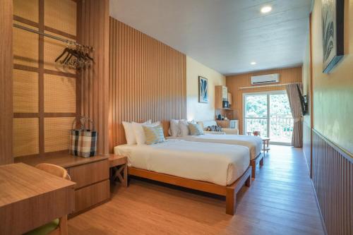 a bedroom with two beds and a window at Ko Tao Paradise Resort in Ko Tao