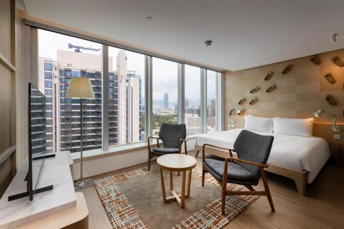 a hotel room with a bed and a table and chairs at Hotel Madera Hong Kong in Hong Kong