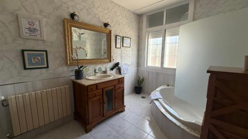 a bathroom with a sink and a tub and a mirror at Apartamento en Casa Tía María in Bueu
