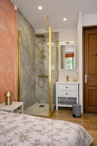 a bathroom with a shower and a bed and a sink at La myrtillette in Luchon