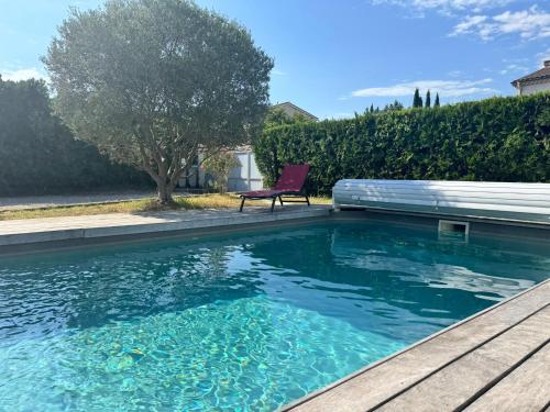 a swimming pool with a chair sitting next to it at Appartement en Luberon in Pertuis