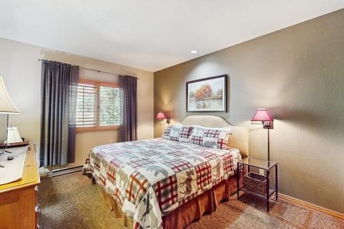 a bedroom with a bed and a desk with two lamps at Cascade 347 in Durango Mountain Resort