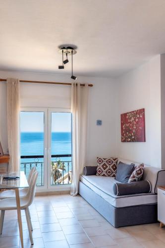 a living room with a couch and a view of the ocean at Corfu Glyfada Beach Apartment 91 in Glyfada