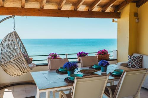 a dining room with a table and a view of the ocean at Corfu Glyfada Beach Apartment 91 in Glyfada