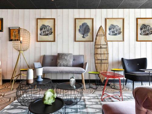 a room with a couch and chairs and tables at ibis styles La Rochelle Thalasso Chatelaillon in Châtelaillon-Plage