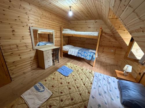 a room with two bunk beds in a log cabin at Te Oli Theth in Theth