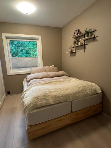 a bedroom with a bed with a window and shelves at Spacious apartment with 3 Bedrooms & balcony in Voss in Vossevangen