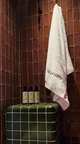 a towel and four bottles on a suitcase in a bathroom at VILLA LORES Adults Only Retreat near Sanxenxo & O Grove in Lores