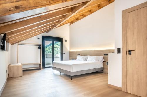 a bedroom with a bed and a wooden ceiling at Hotel Truita in Cangas del Narcea