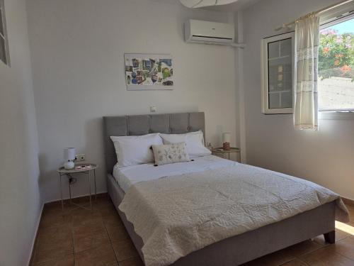 a bedroom with a bed and a window at Aegean Balcony in Tinos
