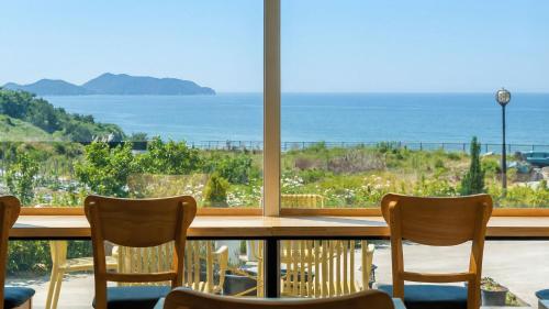 a table with chairs and a view of the ocean at Yeosu Everyday Small Changes Pension in Yeosu