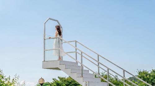 a woman is standing on a stairway at Yeosu Everyday Small Changes Pension in Yeosu