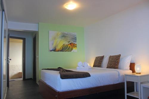 a bedroom with a bed and a painting on the wall at The Wave House - Seaside Haven in Jardim do Mar