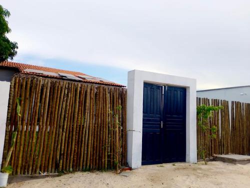 a fence with a blue door in front of a house at Casa Rio - Santo Amaro in Santo Amaro