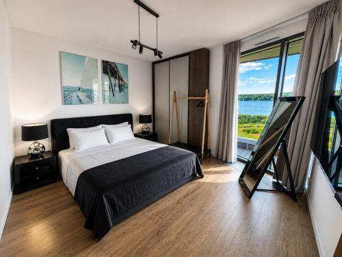 a bedroom with a bed and a view of the ocean at Zegrze Riva with the view in Zegrze Południowe