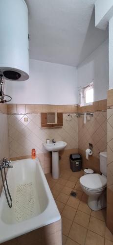 a bathroom with a tub and a toilet and a sink at Imeros Summer Home in Ímeros