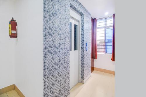a bathroom with blue tiles on the wall at Super Collection O Sixmile Guwahati Formerly Hotel Gangotri in Guwahati