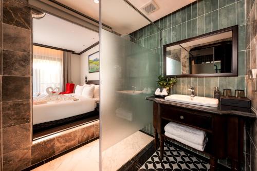 a bathroom with a bed and a sink and a mirror at Tam Coc Holiday Hotel & Spa in Ninh Binh