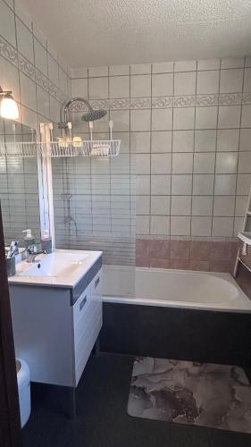 a bathroom with a sink and a tub and a toilet at Les Freds in Ventavon