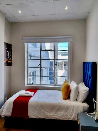 a bedroom with a large bed with a window at Pepper Korrel - Paarl - Self Catering Apartment in Paarl