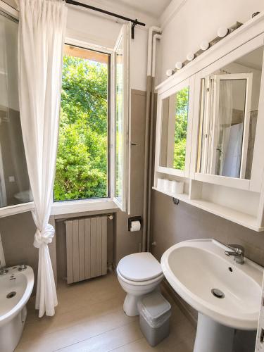 a bathroom with a toilet and a sink and a window at Garden Lodge by Veneto Villa in Albignasego