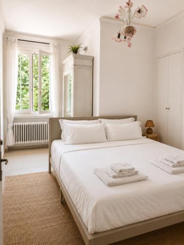 a white bedroom with a large bed with white sheets at Garden Lodge by Veneto Villa in Albignasego