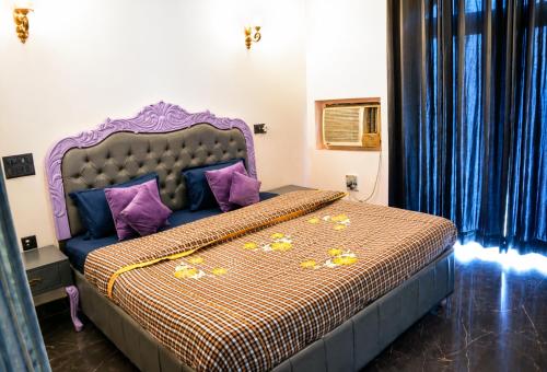 a bedroom with a bed with purple and purple pillows at Maya Hotel & Restaurant in Agra