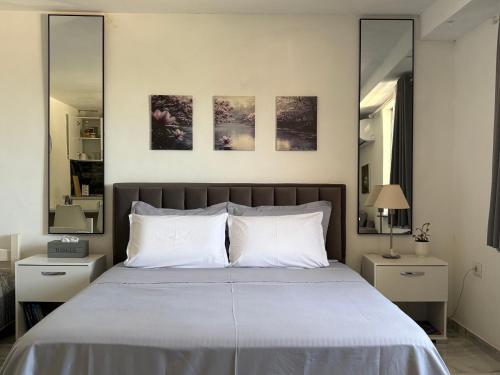 a bedroom with a large bed with two mirrors at Tiny home at the castle in Shkodër