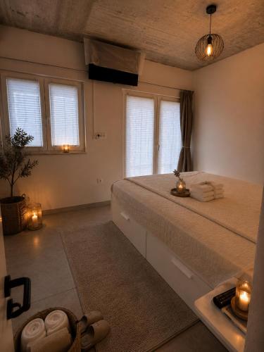 a bedroom with a large bed with candles and windows at Apartment Bunja No3 in Drage