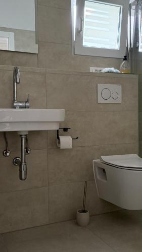 a bathroom with a sink and a toilet and a window at Apartment Bunja No3 in Drage