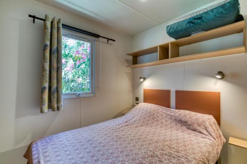 a bedroom with a bed and a window at Bungalow in Agde