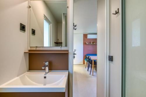 a bathroom with a sink and a mirror and a table at Bungalow in Agde