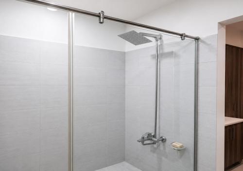 a shower with a glass door in a bathroom at Zameen Opal Executive 2-Bed Suite in Lahore