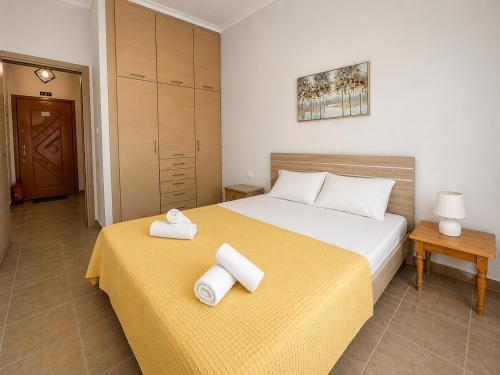 a bedroom with a bed and two towels on a table at Otium Apartment in Nea Peramos